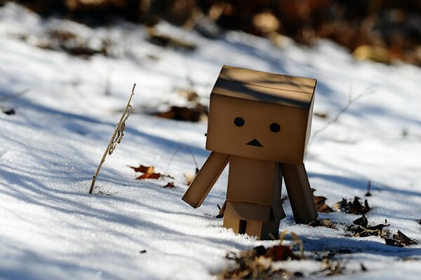 Petit homme mignon en carton en hiver. Neige fondante