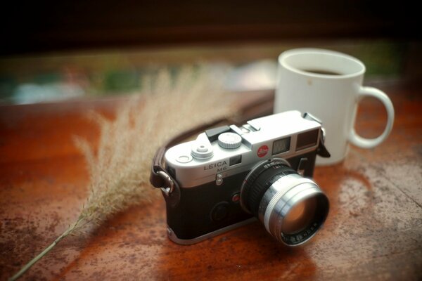 Leica Schwarz-Silber-Kamera mit Kordelzug auf dem Tisch mit Kaffeetafel