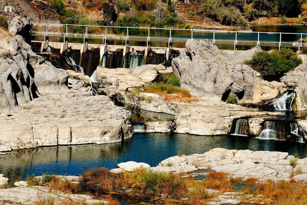 Dam on the river, white stones with a waterfall