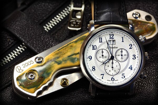 A beautiful watch that lies on top of a folding knife