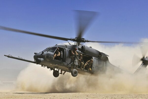 Helicopter lands in the desert kicking up dust