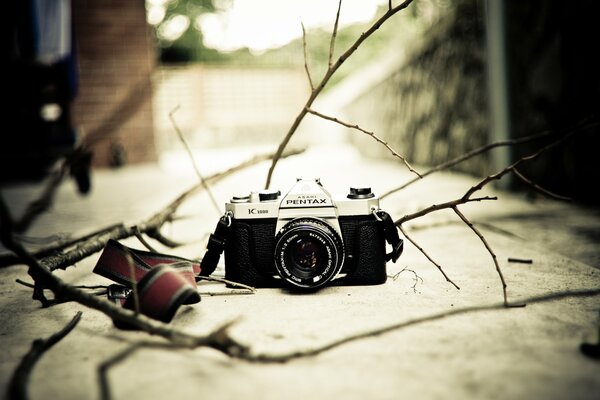 Black Pentax k1000 camera with a tie on the road