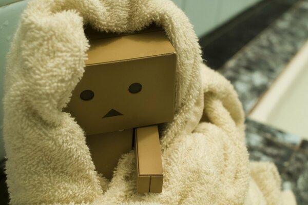 Cardboard man after a shower in a towel