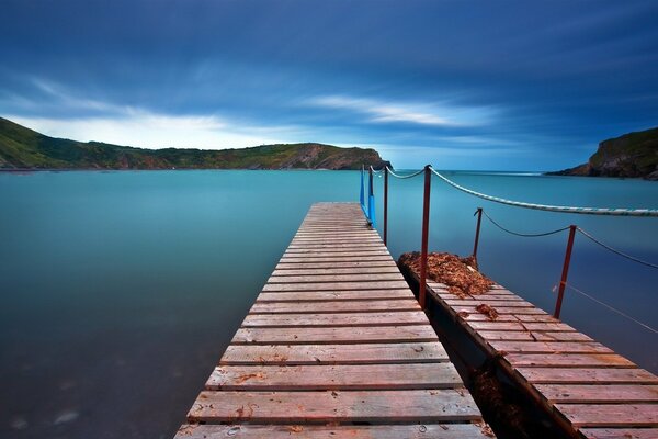 Quai en bois dans la surface turquoise