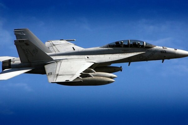 A Boeing military plane flies in a rich blue sky