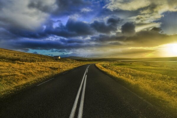 An empty highway leads into the sunset