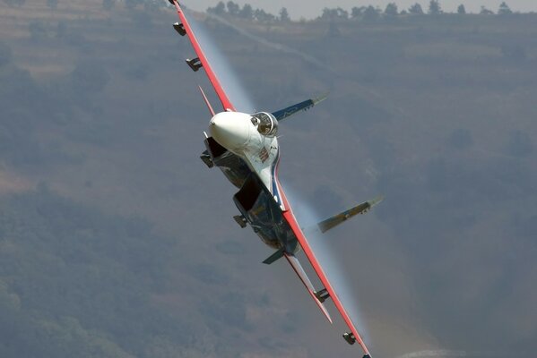 Caza su-27 flotando entre las montañas