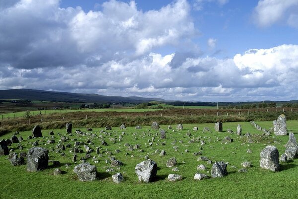 A circle of stones on a green meadow is white