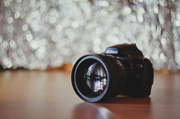 Nikon camera with a lens on the background of the bokeh effect