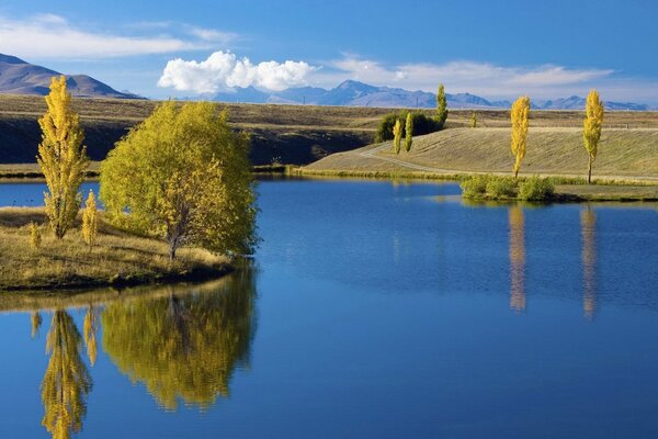 Insel im blauen See im frühen Herbst