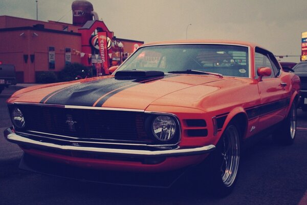 Roter Ford Mustang auf dem Hintergrund der Beschilderung