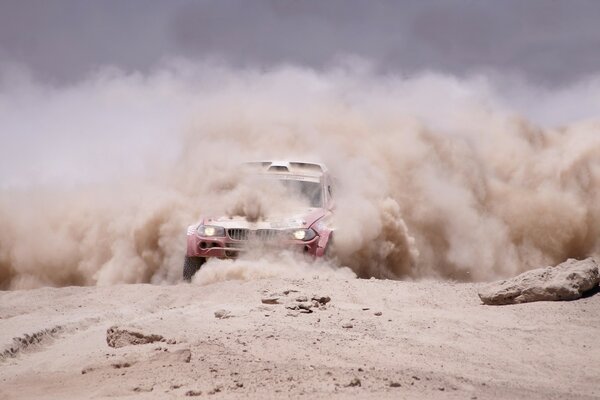 An SUV in a curtain of dust. Dakar Rally