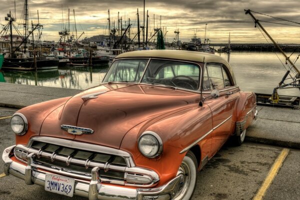 Vintage car at the marina at sunset