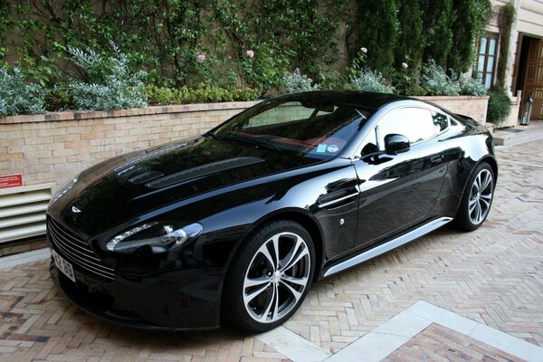 Auto nera, vantage, aston martin sul marciapiede