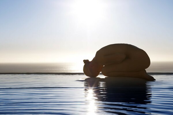 Ragazza che fa yoga vicino all acqua