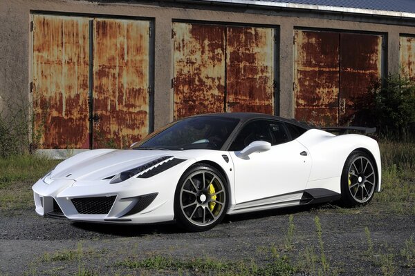 Ferrari blanco con techo negro en el fondo de los garajes