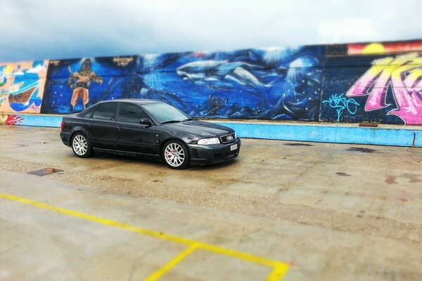 A black Audi at the painted gryfiti wall