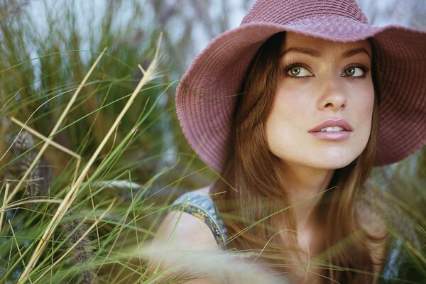 Olivia con un sombrero sobre un fondo de hierba