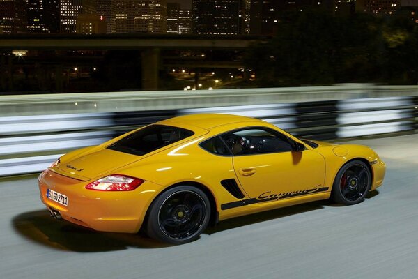 Porsche Cayman corre lungo la pista notturna