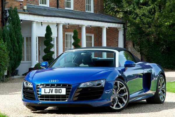 Azul Audi R8 Spyder en el fondo del patio de la casa