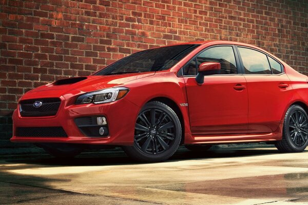 Voiture rouge Subaru sur fond de mur de cannelle