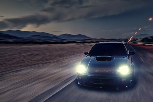 Subaru impreza in nero con fari luminosi