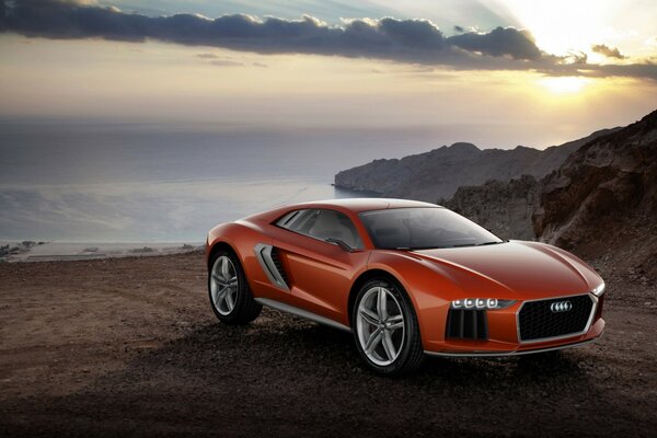 Red audi car on the background of rocks