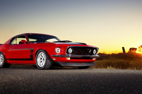 La supercar Mustang boss 302 rossa guida al tramonto