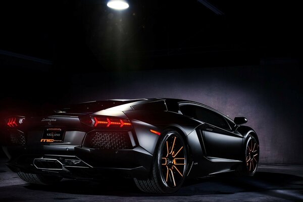 Schwarzer Lamborghini Aventador unter dem Lampenlicht