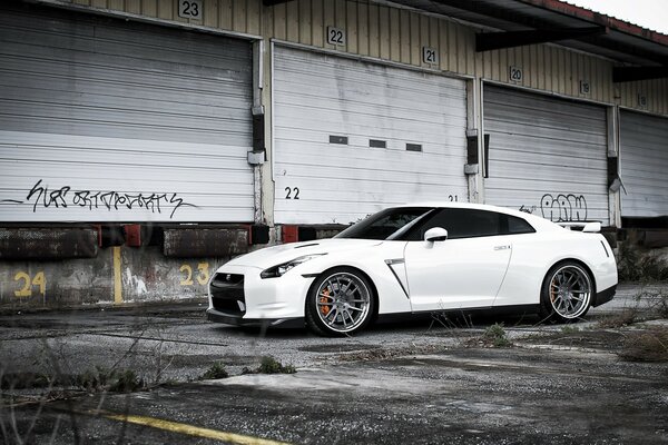 Sporty white Nissan next to the warehouse