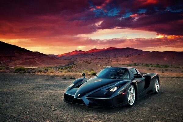 Black car on the background of mountains and dark sky