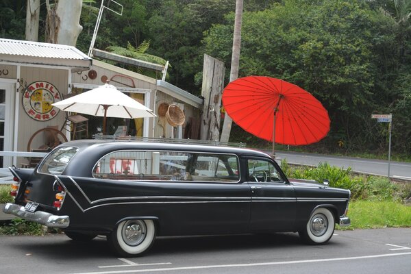 Largo coche retro en paraguas rojo