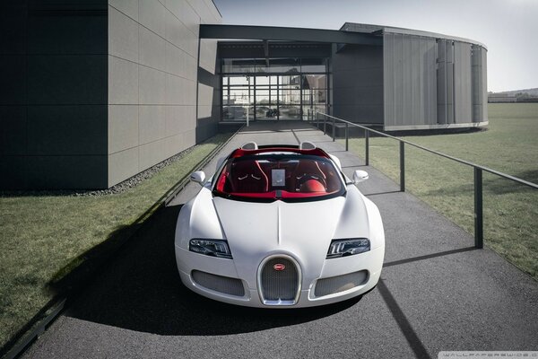 White Bugatti Veyron sports car on the background of a modern house