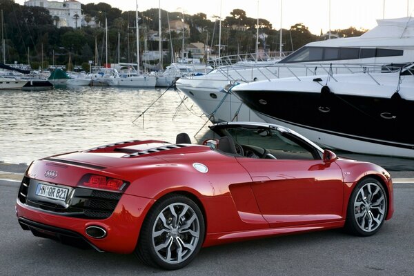 Voiture Audi rouge d origine près de yachts. Embarcadère