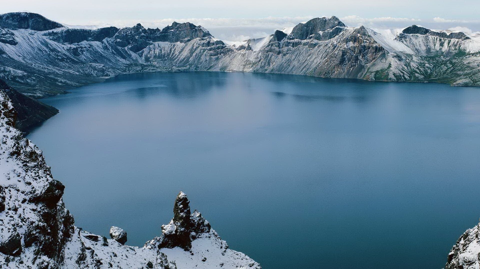 blauer see berge um schnee berge see glatte oberfläche winter schneebedeckte berge gipfel landschaft natur landschaft