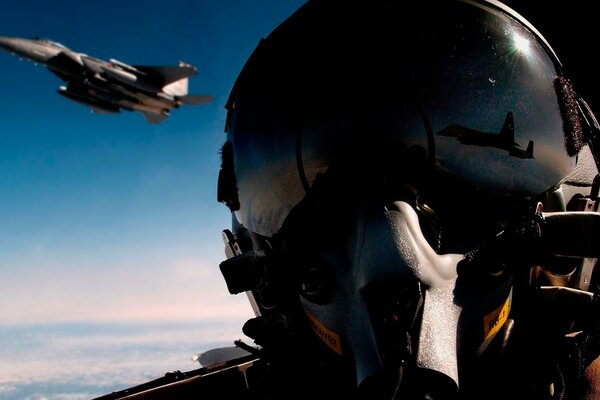 Piloto de caza con casco en el fondo de un avión volador