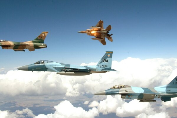 Cuatro aviones volando sobre las nubes en el cielo azul