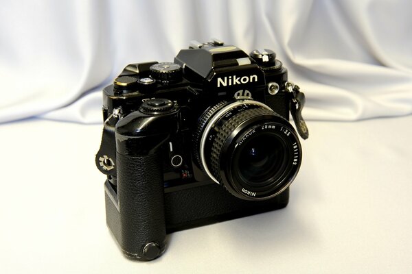 Fotocamera nikon fa con obiettivo singolo su sfondo chiaro