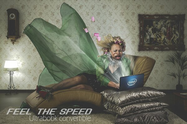 Donna con bigodini soffia via dalla velocità di Internet in un computer portatile