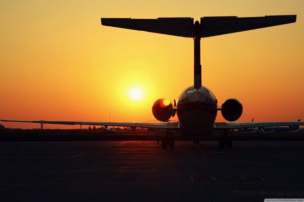 Silhouette of an airplane against the background of sunrise