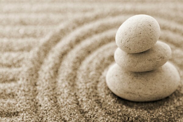 Pyramide de trois cailloux, en cercle sur le sable