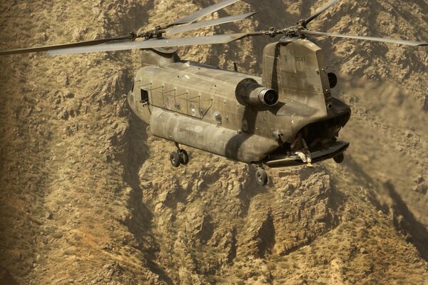 Flying Chinook helicopter on the background of mountains