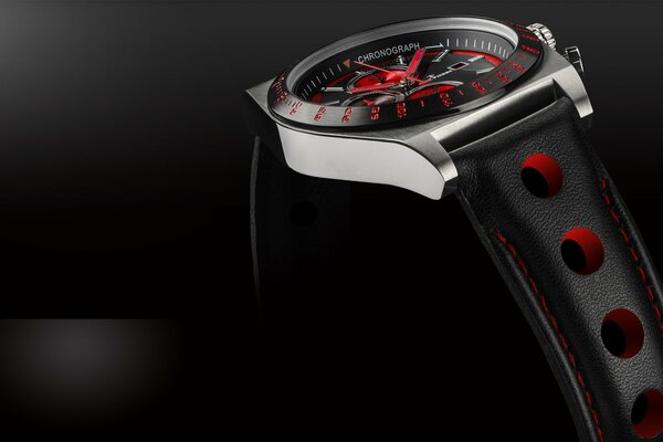 The hand watch is black with red