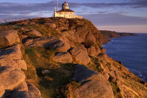 Phare sur le rebord de la mer au coucher du soleil