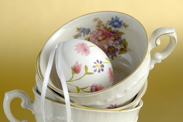 A painted egg in a porcelain mug