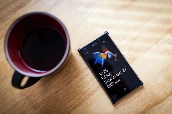 Nokia phone and coffee mug on wooden table