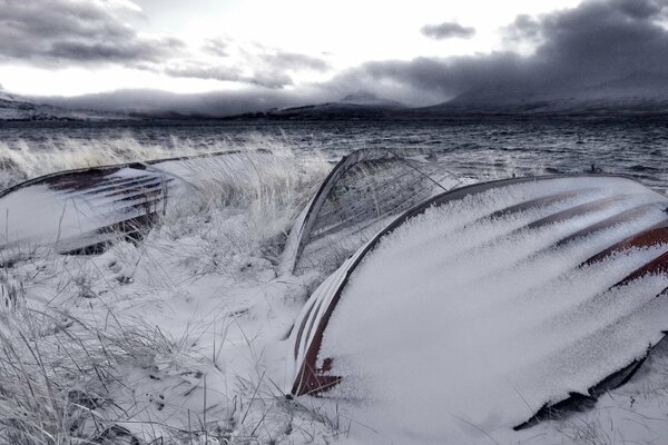 Boats under the snow against the dark sky