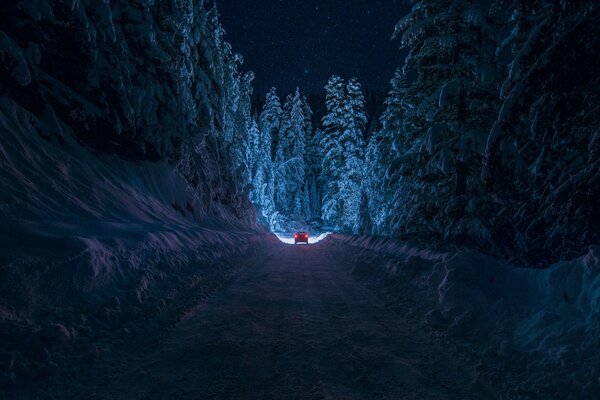 Coche en la carretera nocturna de invierno