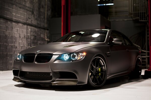 A beautiful grey BMW m3 car is parked in the garage