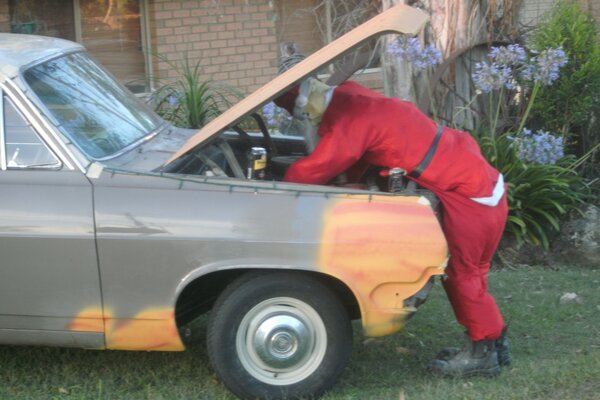 Photo of Santa at Christmas repairing a Holden car